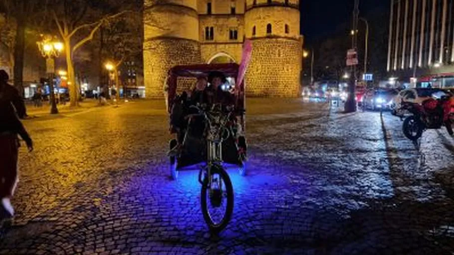 Rickshaw with blue lights on cobblestone street.