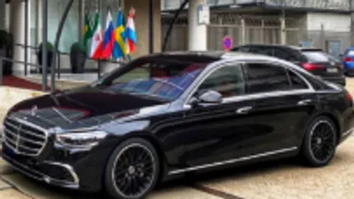 Black luxury car parked outside building.