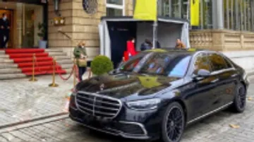 Black car parked outside a luxury hotel entrance.