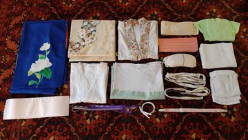 Kimono-Kleidungsstücke auf gemustertem Teppich ausgelegt.