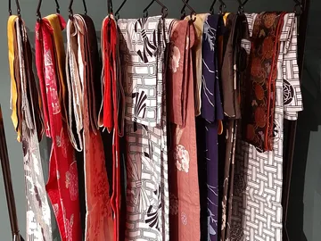 Variety of colorful kimonos hanging on rack.