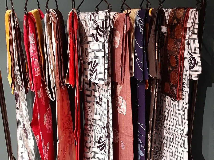 Verschiedene bunte Kimonos hängen an einem Gestell.