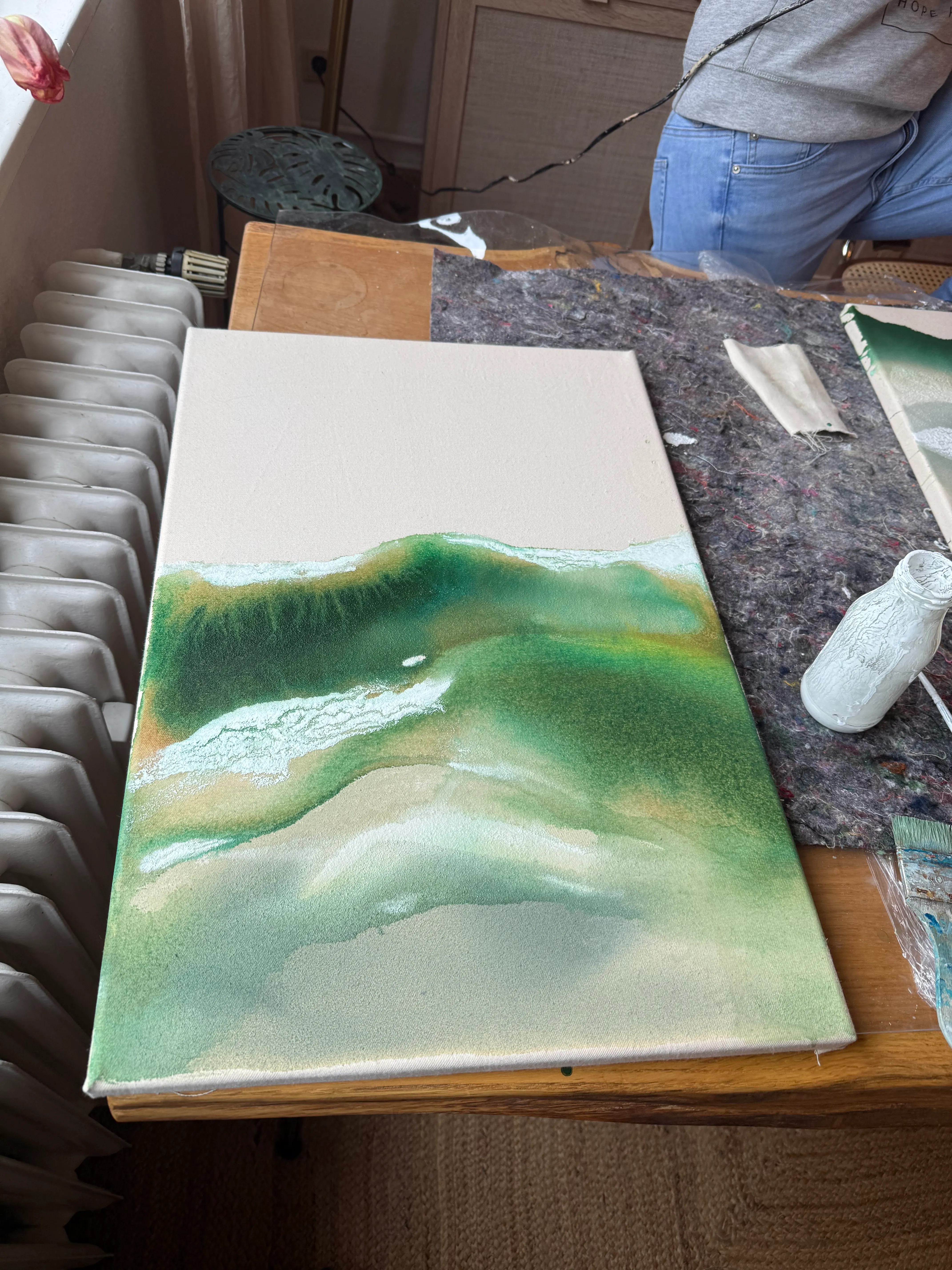 Leinwand mit grüner Farbe auf Holztisch.