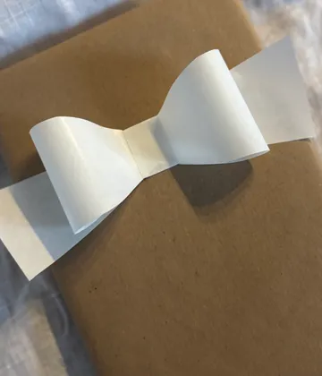 Brown gift wrap with white paper bow.