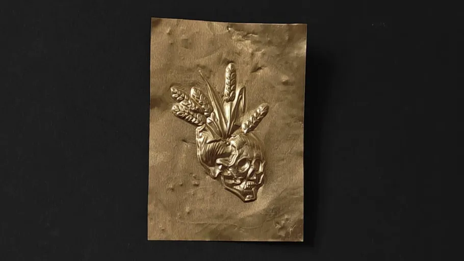 Gold skull with wheat on black background.