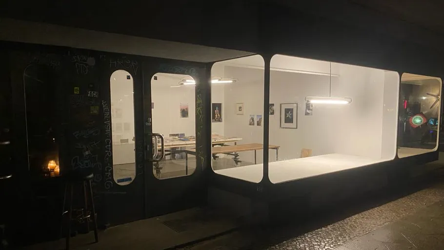 Kunstgalerie-Innenraum durch große Fenster sichtbar.