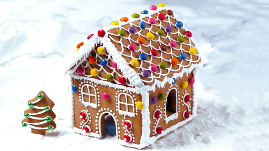 Gingerbread house with candy decorations on snow.