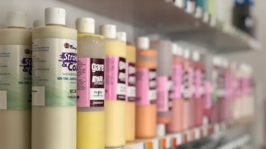 Farbflaschen auf Regalen aufgereiht.