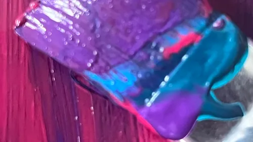 Pinsel malt lila, rote, blaue Striche.