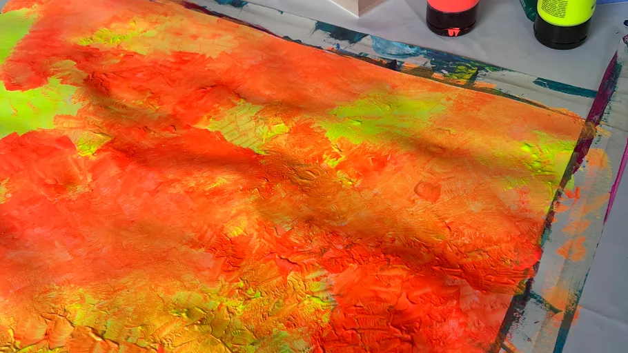 Colorful abstract painting with paint tubes nearby.