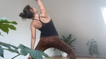 Woman practicing yoga in a bright room.
