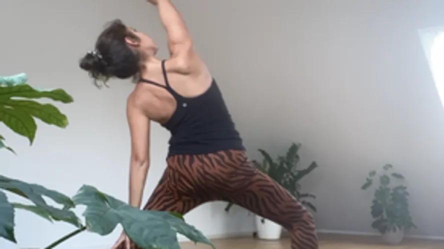 Woman practicing yoga in a bright room.