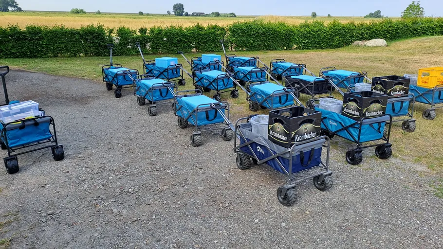 Blaue Wagen und Kisten auf Kiesweg.