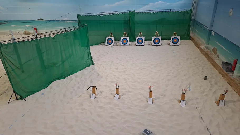 Bogenschießhalle mit Sand und Zielscheiben.