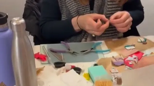 Person bastelt mit Werkzeugen an einem Tisch.