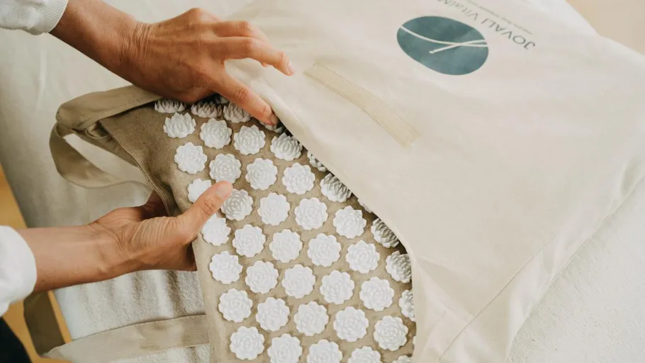 Hands placing acupuncture mat into a bag.