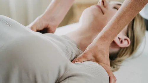 Person receiving shoulder massage in relaxed setting.