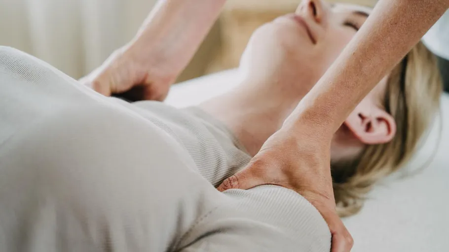 Person erhält Schultermassage in entspannter Umgebung.