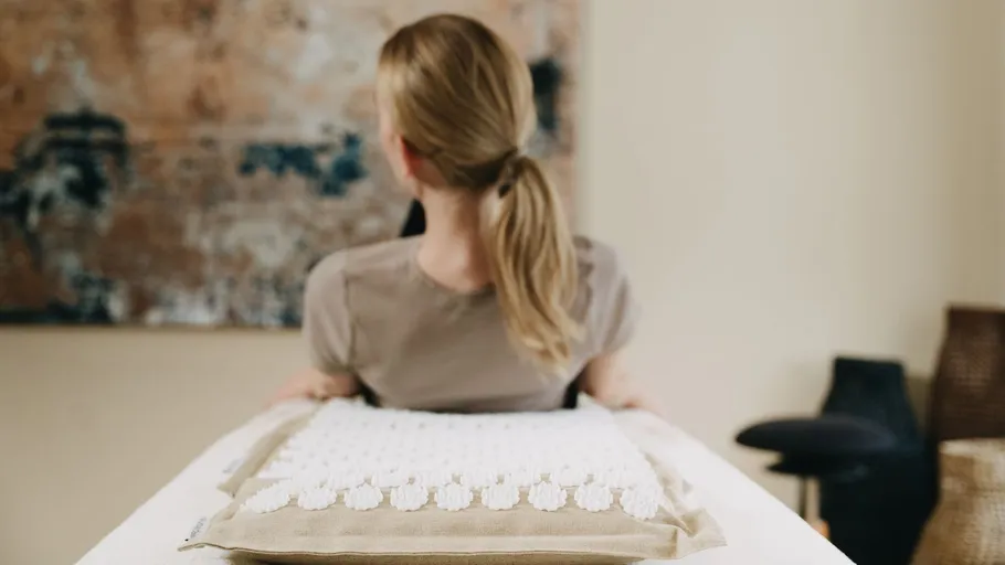Person with ponytail facing away in a room.