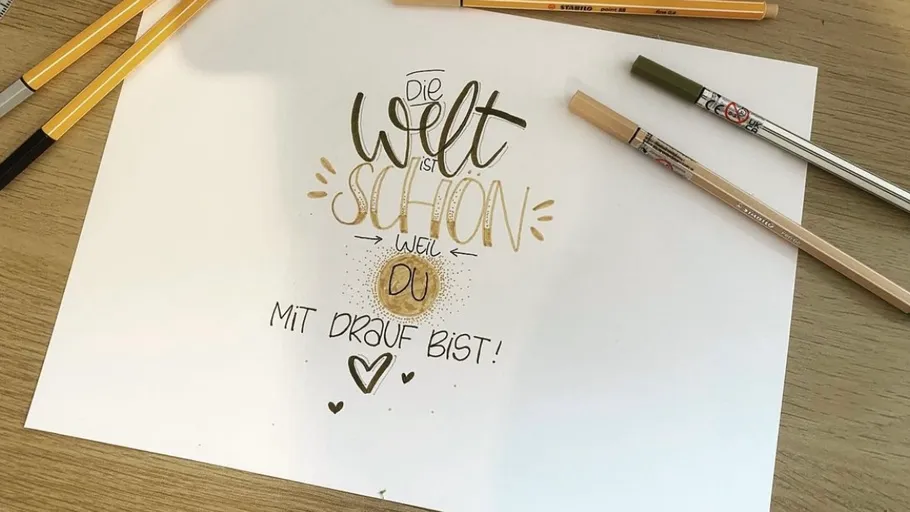 Hand-lettered quote with pens on a table.