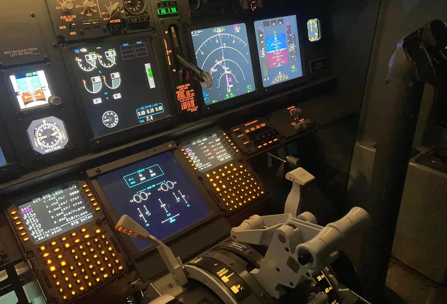 Flugzeugcockpit mit beleuchteten Bedienfeldern.