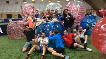 Group of men with inflatable balls indoors.