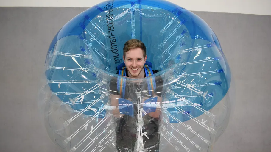 Man inside clear inflatable bubble suit.