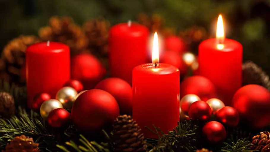 Red candles and ornaments on a wreath.