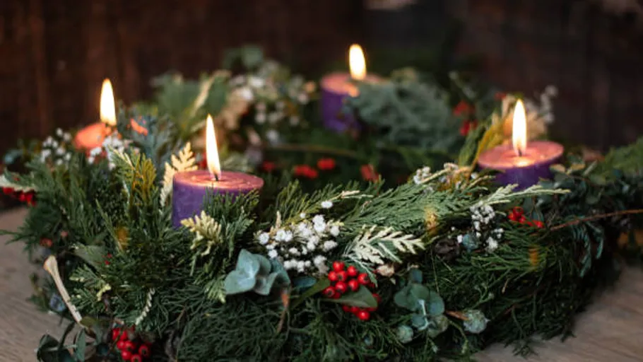Advent wreath with four lit candles.