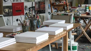Kunststudios Tisch mit leeren Leinwänden.