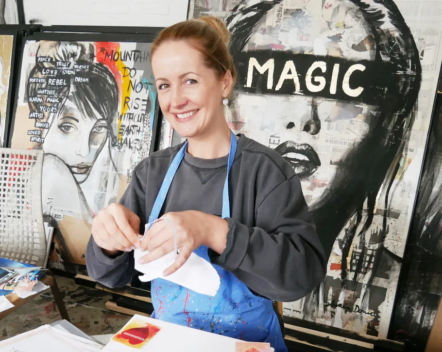 Woman smiling in art studio with paintings.