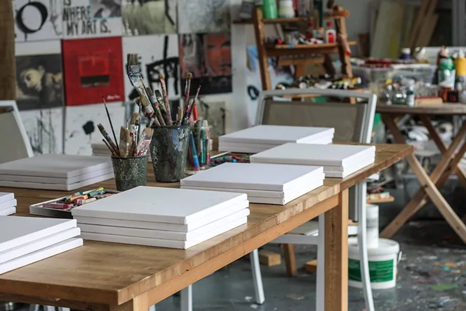 Art studio with canvases and brushes on tables.