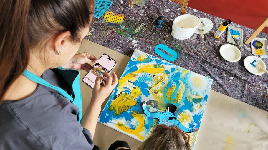 Person fotografiert buntes Gemälde im Kunststudio.