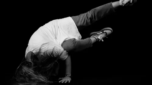 Person breakdancet auf einer Hand im Studio.