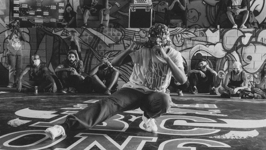 Tänzer breakdancing in urbanem Graffiti-Umfeld.