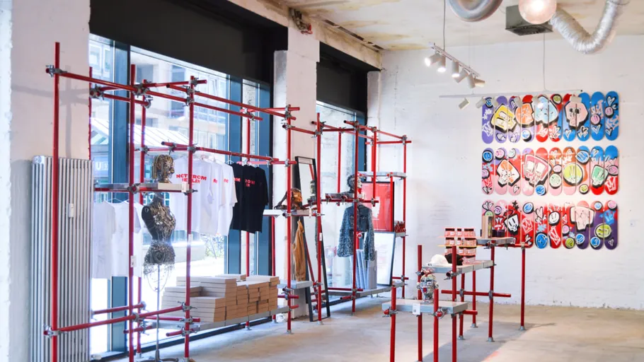 Store interior with art and clothing displays.