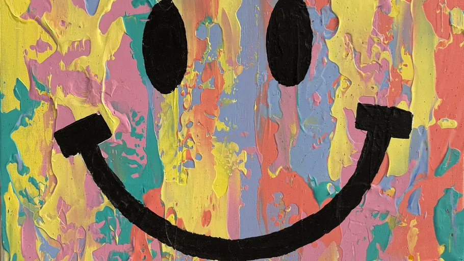 Colorful paint smiley face on canvas.
