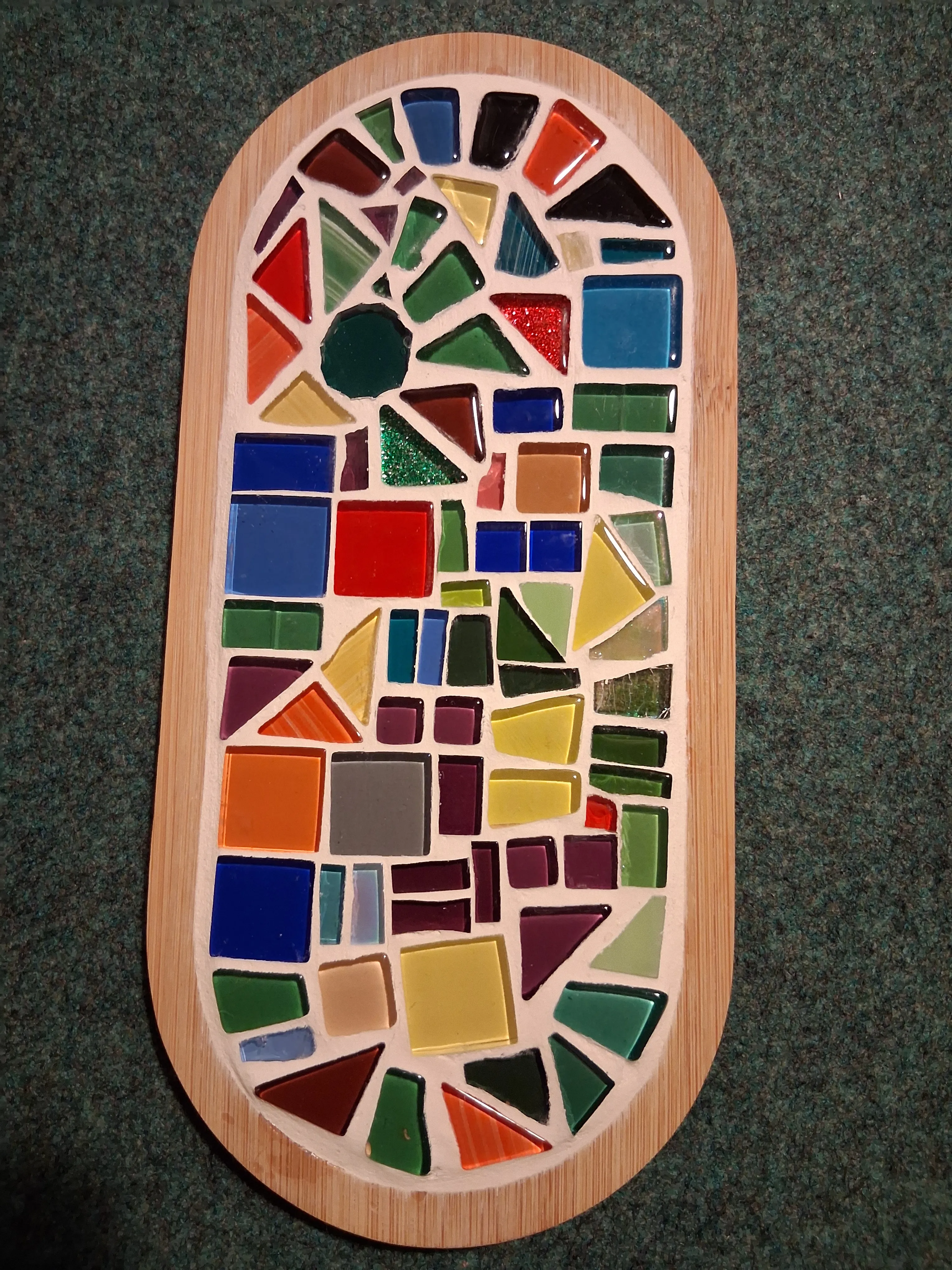 Buntes Mosaik auf Holzbrett.