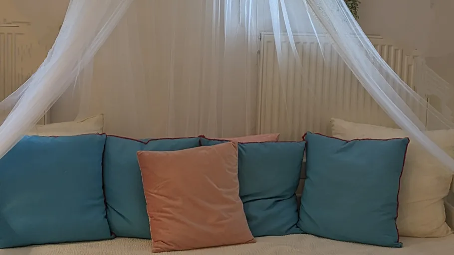 Blue and pink pillows on a cushioned seat.