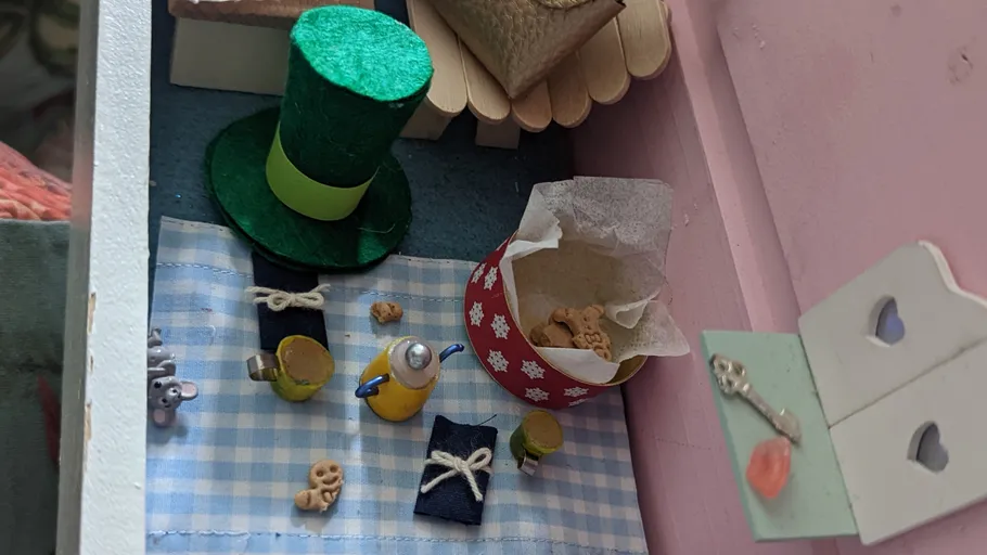 Miniature picnic with top hat and food items.