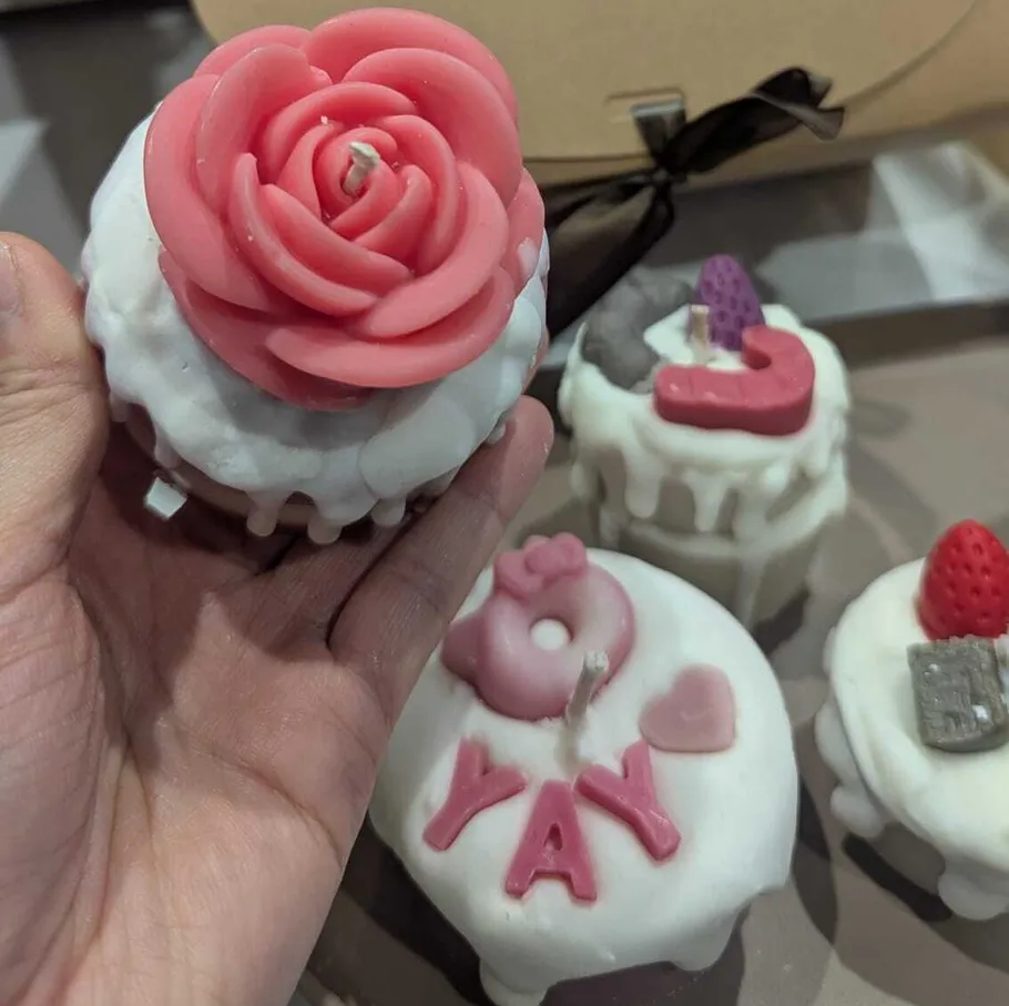 Cupcake-shaped candles with decorative tops.