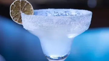 Frostiges Cocktailglas mit Limettenscheibe als Garnitur.