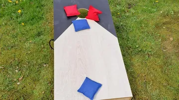 Cornhole-Brett mit bunten Bohnensäckchen im Freien.