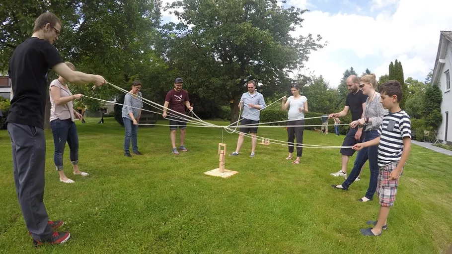 Personen spielen ein Teamspiel im Freien.