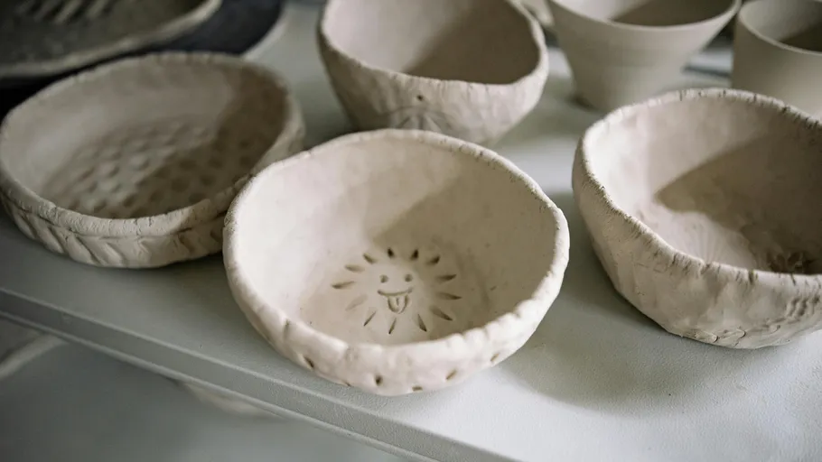 Clay bowls with sun motif on table.