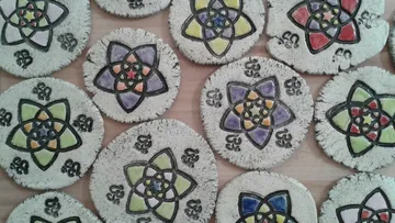 Colorful mandala coasters on wooden table.