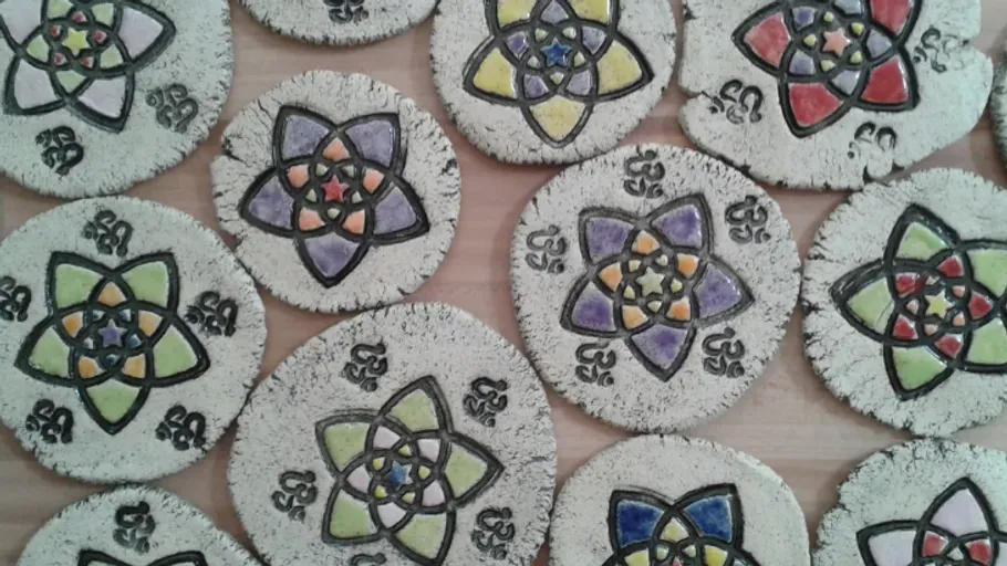 Colorful mandala coasters on wooden table.