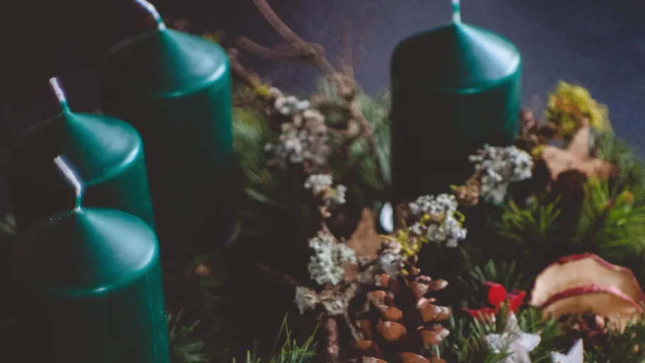 Four green candles in a festive wreath.
