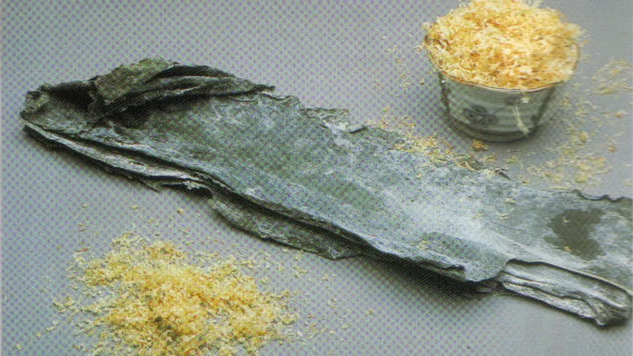 Dried seaweed and wood shavings on table.