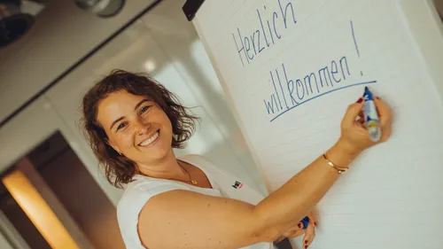 Woman writing on flipchart in office.